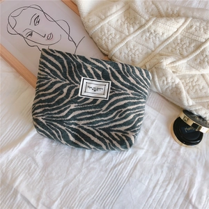 Close-up of zebra pattern canvas clutch bag featuring Time To Party fabric patch detail