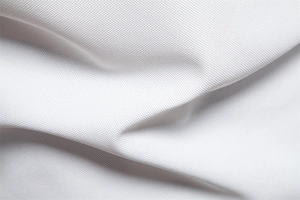 Close-up of white pique polo fabric showing detailed breathable mesh texture and weave