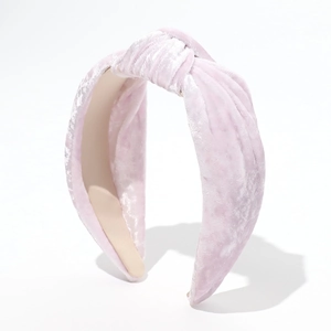 Detail shot of the soft velvet texture and knot design on the pink padded headband