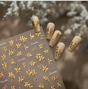 Detail of 3D gold floral nail stickers with intricate flower patterns and Sunshine text
