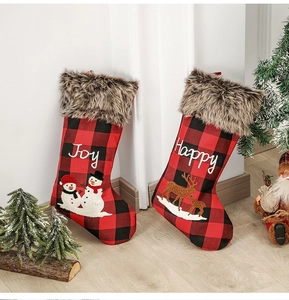Détail de chaussettes de Noël à carreaux rouges et noirs avec broderies Joy et Happy