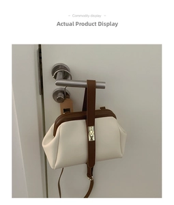 Detail of vintage doctor bag featuring cream and brown contrast with gold metal clasp