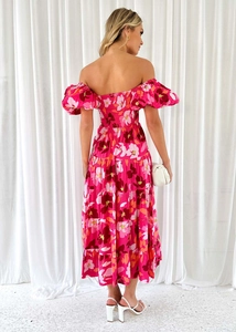 Dettaglio dell'abito a fiori rosso rosa con gonna a balze e scollo a barca sul retro