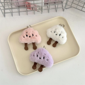 Detailed close-up of fluffy cloud plush keychains in pink, white, and purple colors