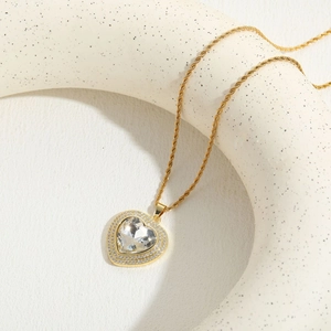 Detail of a sparkling heart-shaped zircon pendant on a golden rope chain necklace