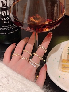 Elegant gold bow rings with pearls and rhinestones shown in a sophisticated lifestyle setting