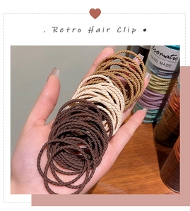 Detail showing the spiral woven texture of elastic hair ties in earthy brown and beige tones