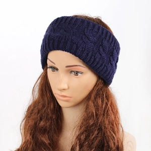 Detail of dark blue cable knit headband on a model showing wide fit and ear protection