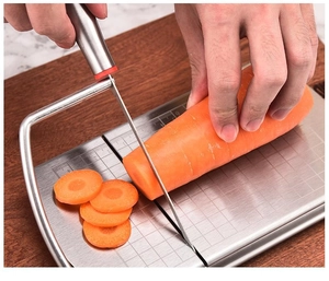 Detail showing stainless steel slicer cutting carrots on a built-in scale board