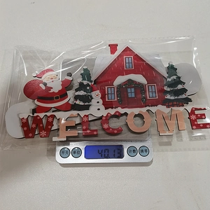 Detailed view of a wooden Santa Claus Welcome sign being weighed on a digital scale