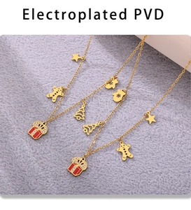 Detail of PVD gold plated jewelry set featuring enamel Christmas charms and gingerbread man