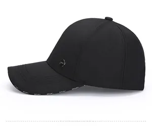 Detail of black baseball cap with metal SPORT badge and letter printed brim edge