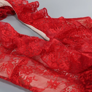 Close-up of red floral lace fabric showing delicate texture and smooth inner lining