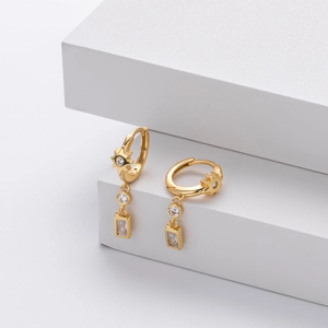 Detailed shot of gold hoop earrings featuring star, round, and square zircon charms