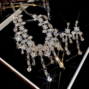 Détail du collier à pampilles en fleurs argentées avec des strass étincelants pour soirées