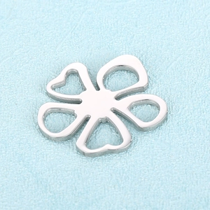Macro shot of silver stainless steel hollow clover charm with polished metallic finish