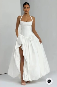 Détail d'une élégante robe licou blanche avec fente haute et taille cintrée affinée