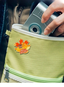 Detail of Nanjing Qixia Mountain enamel pin badge on a yellow canvas travel bag