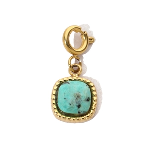 Detail of square turquoise stone pendant with vintage gold textured metal frame and spring clasp