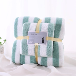 Close-up of green striped coral fleece towel set with decorative yellow ribbon gift wrap