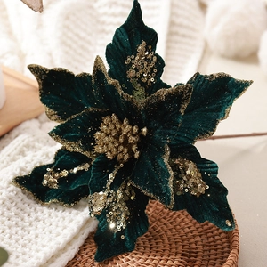 Poinsettia de Noël en velours vert foncé avec paillettes dorées sur fond tricoté doux