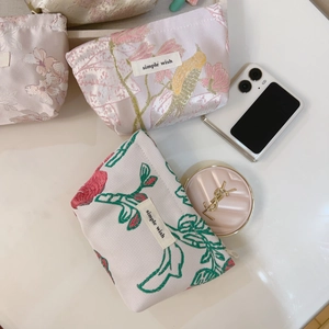 Detailed view of floral jacquard mini storage pouches with embroidery and zipper closure