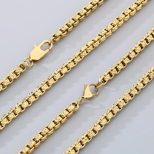 Detailed close-up of faceted gold chain link texture and lobster clasp on necklace
