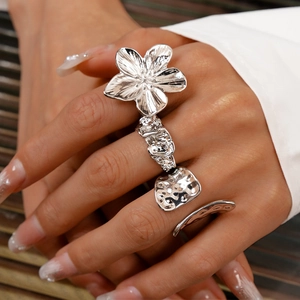 Detailed view of silver flower ring with hammered texture worn on finger