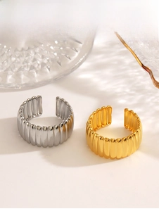 Close-up of wavy gold and silver stainless steel rings on decorative glass