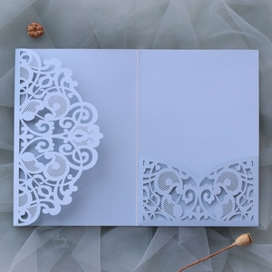 Detail view of light blue laser-cut invitation card with European lace pattern on tulle