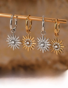 Detailed macro view of four sunburst hoop earrings in gold and silver plating with crystals
