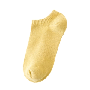 Pale yellow low-cut cotton boat socks with ribbed cuffs for women on white background
