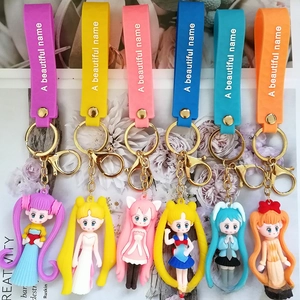 Detail of 6 cartoon figure keychains with colorful silk scarves and golden metal hooks
