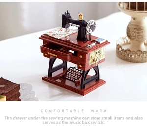 Detail of vintage sewing machine music box showing miniature drawer and winding switch