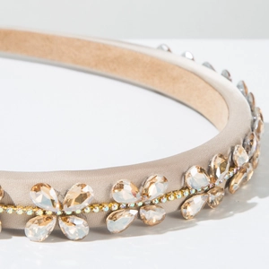 Macro shot of luxury Baroque headband with champagne satin, crystals, and gold chain detail
