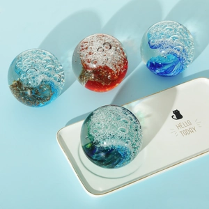 Macro detail of colorful glass wave spheres with inner bubbles on a tray