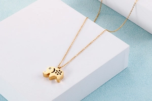 Detailed view of a gold elephant pendant necklace with floral cutouts and a small diamond