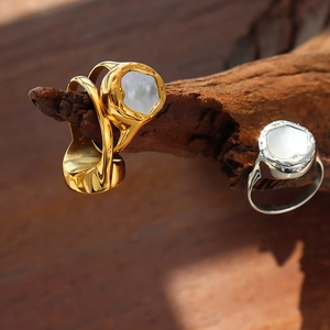 Gold and silver rings with white mother of pearl inlay on textured metal bands
