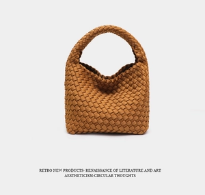 Detail of brown woven leather texture on a retro bucket bag with wide intrecciato pattern