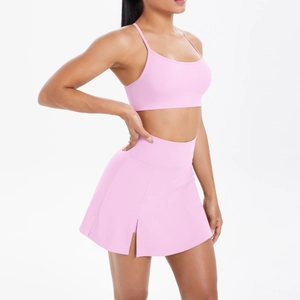 Détail de l'ensemble de yoga rose avec jupe de tennis fendue et brassière à bretelles