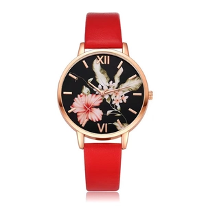 Detail of red leather watch strap and rose gold floral dial with Roman numerals