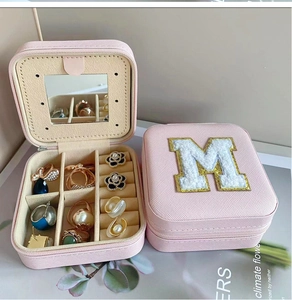 Pink portable jewelry box with M-letter patch, built-in mirror, and multi-grid storage