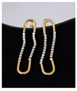 Macro detail of U-shaped gold earrings featuring shimmering cubic zirconia stones