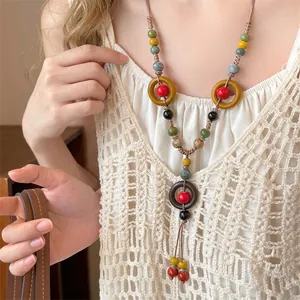 Gros plan des perles en céramique vintage et de l'anneau en bois du collier à glands