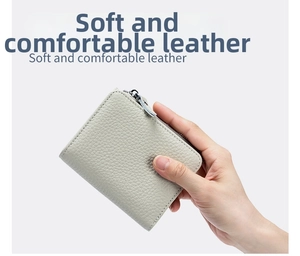 Primer plano de la cartera fina de cuero gris claro con textura litchi y cierre de cremallera