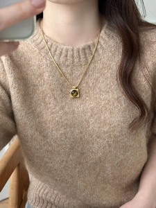 Macro view showing the gold hammered texture square tiger eye stone pendant on the necklace