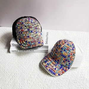 Detail shot of colorful pearl and rhinestone embroidery on black and white baseball caps