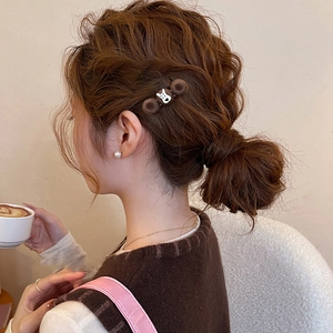 Detail of plush brown polka dot dog hair clip on model with soft warm lighting