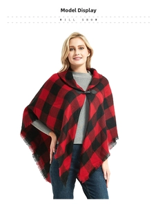 Detail of red and black plaid poncho with leather toggle closure and tassel trim