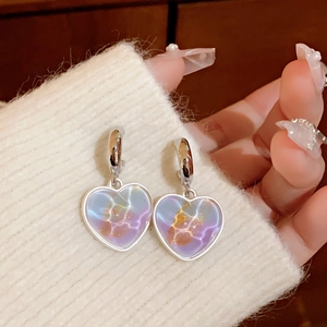 Close-up of heart-shaped earrings with colorful gradient inlay and silver ear hooks